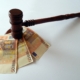 Foto de un mazo de juez con tres billetes de 50 euros debajo, imagen que ilustra el artículo de Ponter Abogados y Asesores sobre "Proporcionalidad en la sanción por no consignar cuotas en la autoliquidación del IVA"