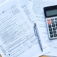 Foto de una calculadora y hojas de la declaración de la Renta 2023 para un artículo nuevo publicado por Ponter Abogados y Asesores